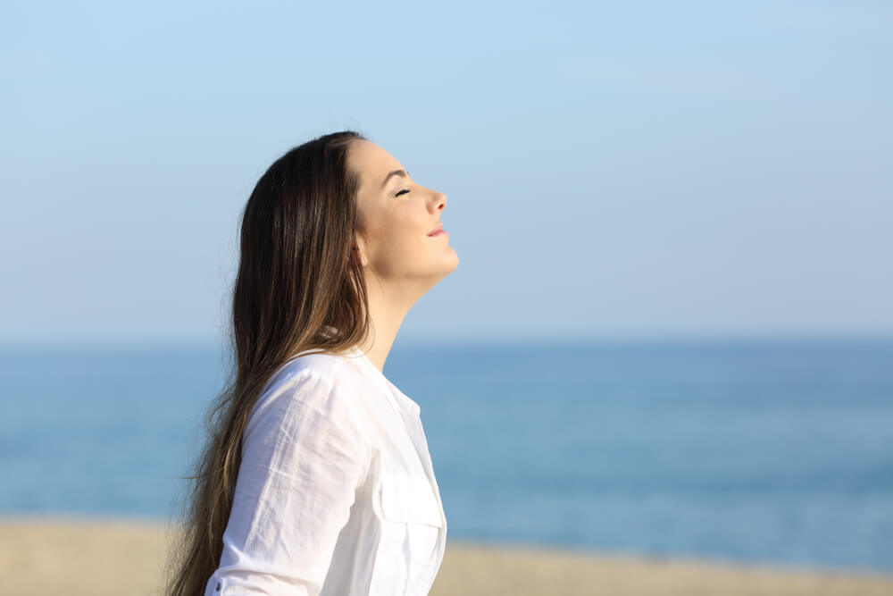 woman relaxing breathing fresh air on the beach