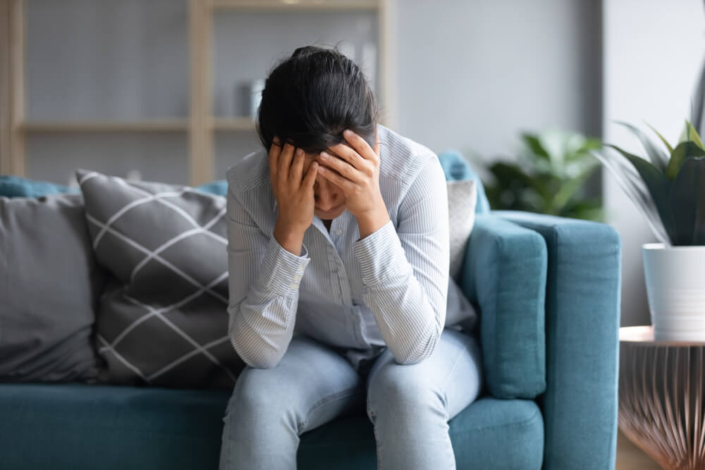Unhappy depressed woman holding head in hands