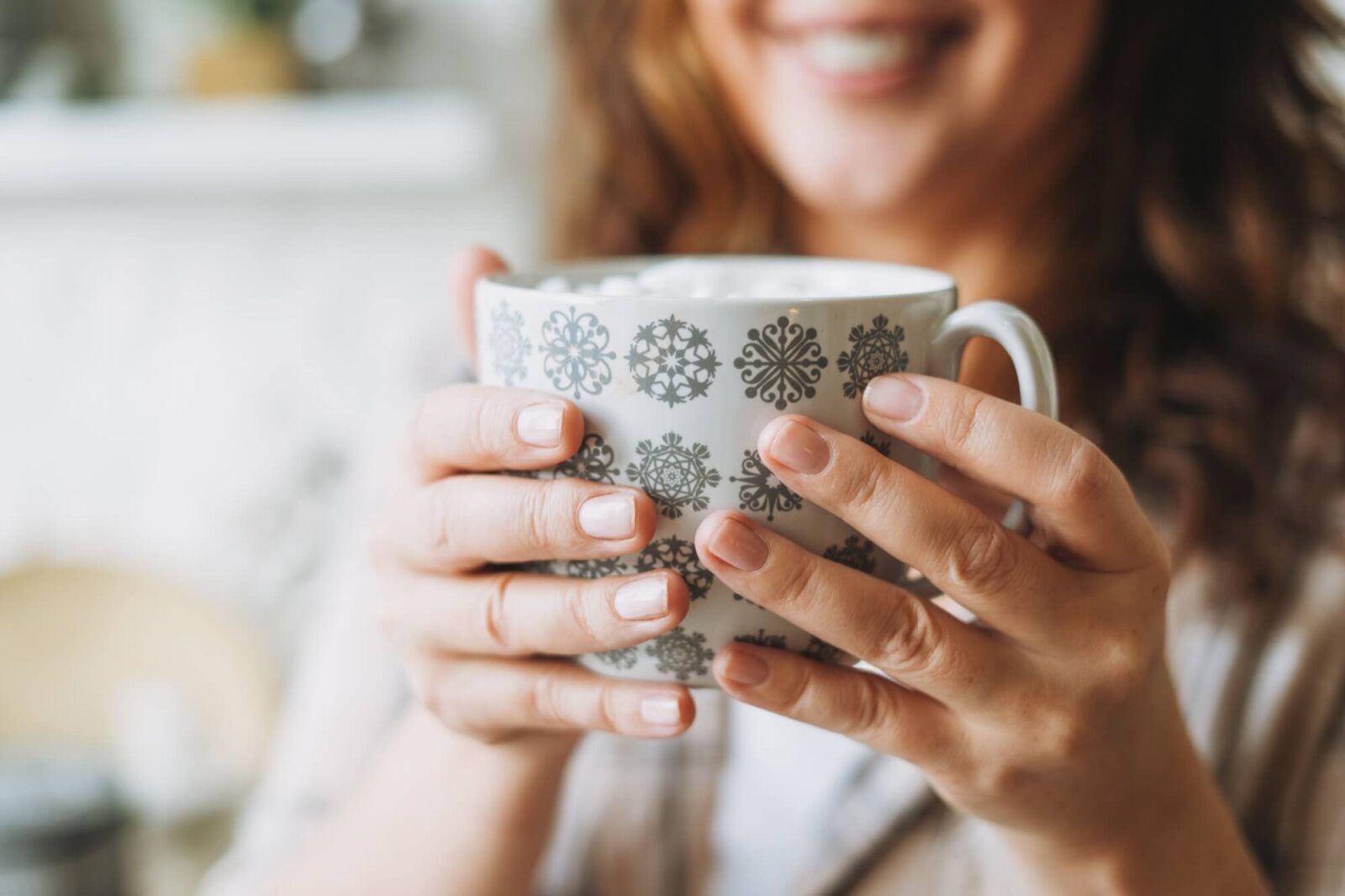 Smiling woman with cup of cacao with marshmallow