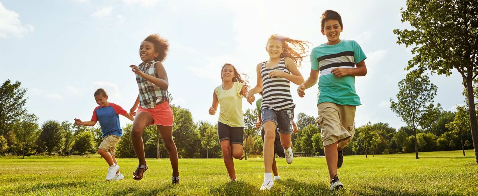 Happy kids running with friends in nature for fun