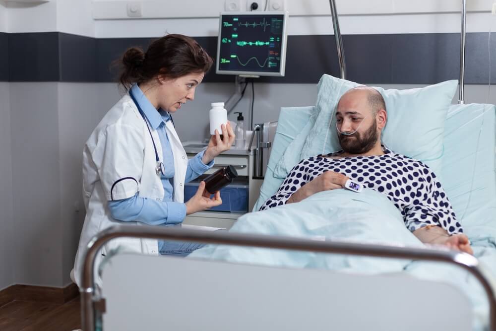 Middle aged man in pain after surgery recieving choice of prescription painkillers