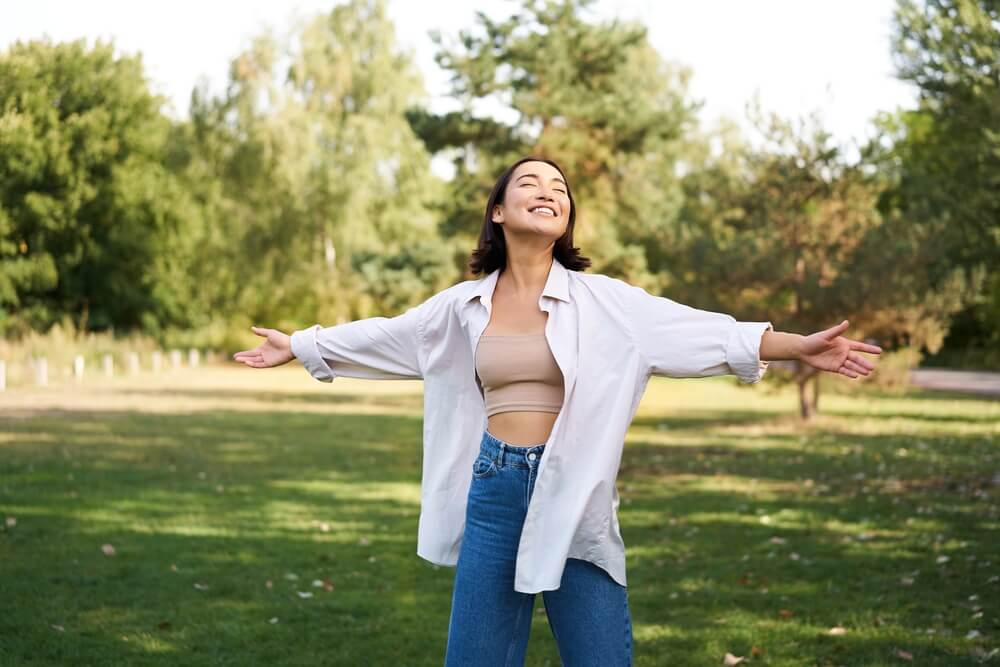 Carefree girl laughing and dancing in park