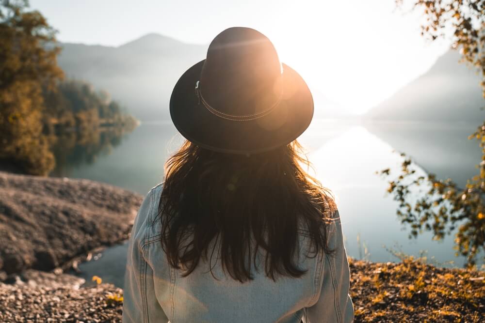 Fashionable young woman with long hair looking at view against lake