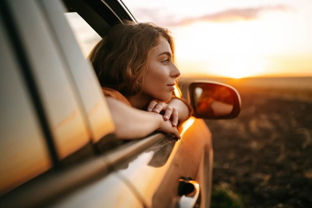 Woman looking out of car window at ease