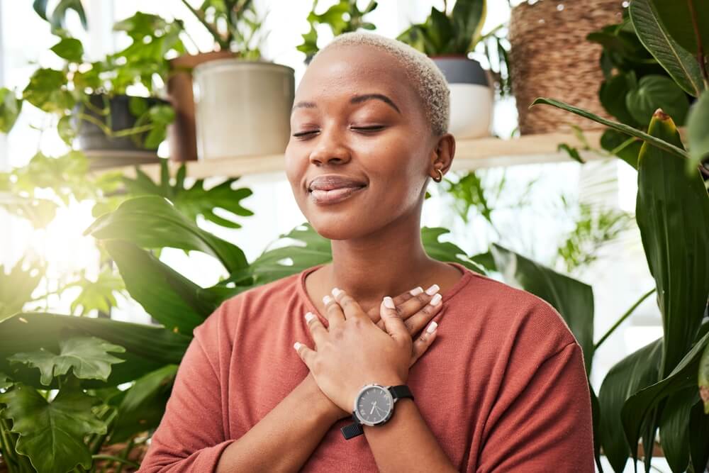young woman by plants for zen meditation in a greenery nursery
