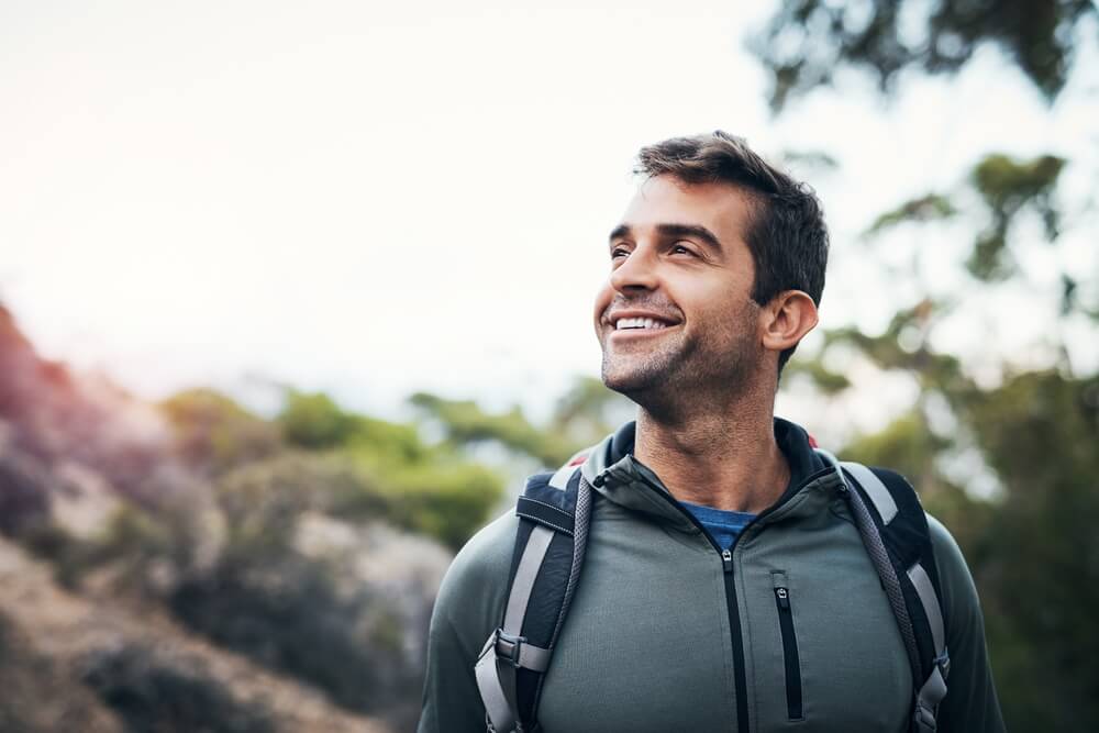 Man smiling while outside on a walk