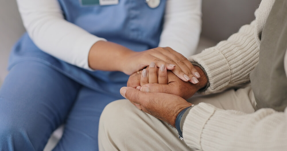 nurse holding hands with person for healthcare service