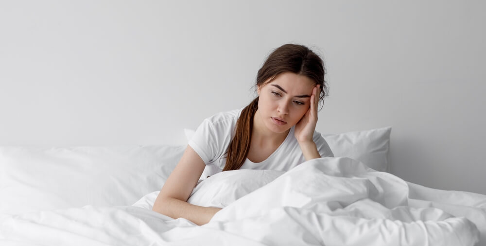 Sad woman suffers from insomnia and headache